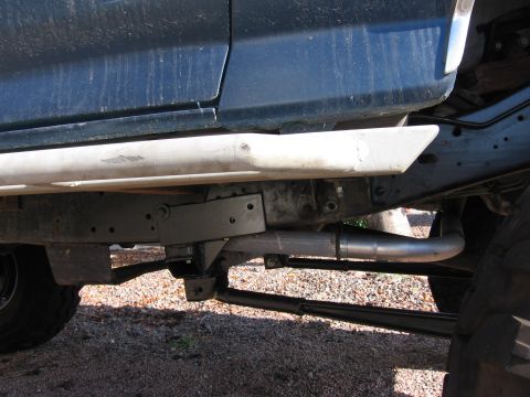 1990 Ford Bronco - The underside of a vehicle is visible, a running board and exhaust system.
