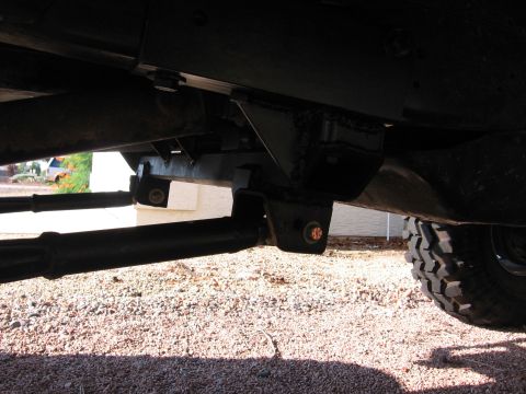 1990 Ford Bronco - Close-up view of the vehicle's underbody, focusing on suspension modifications and a prominent tire.