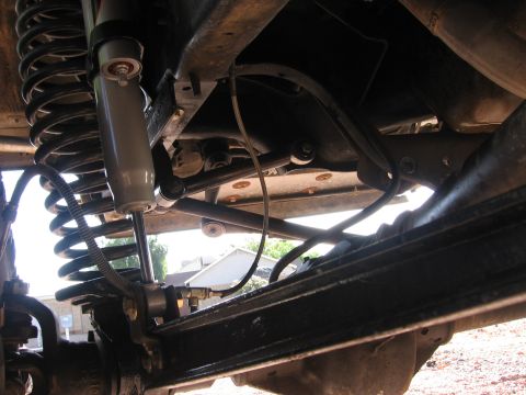 1990 Ford Bronco - Close-up of vehicle suspension components, including a shock and coil spring.