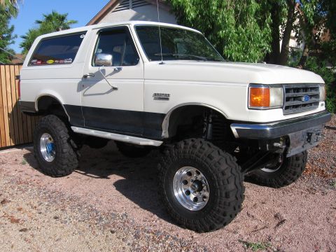 1990 Ford Bronco - This lifted 1990 Ford Bronco features a two-tone paint scheme and prominent off-road tires.