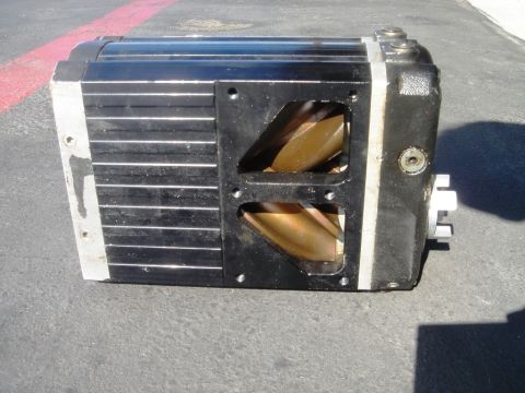 1991 Ford Taurus - A black supercharger with silver fins and exposed gold rotors is shown on asphalt, with a red line in the background.