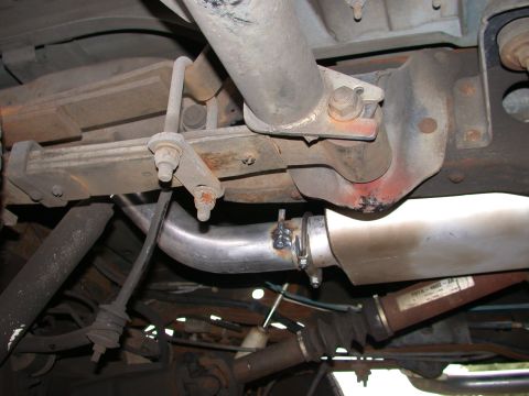 1995 Ford Bronco - A close-up view of the undercarriage reveals the vehicle's exhaust system components and a driveshaft with a label.