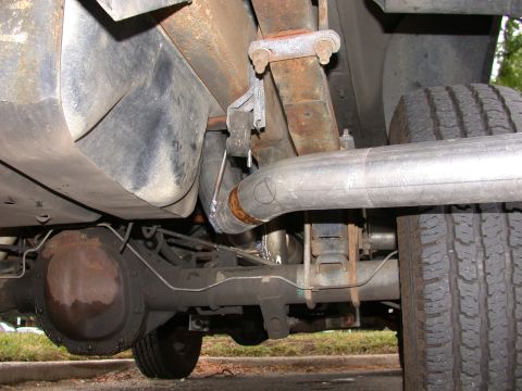 1995 Ford Bronco - Close-up view of the undercarriage, focusing on the exhaust system and rear axle components.