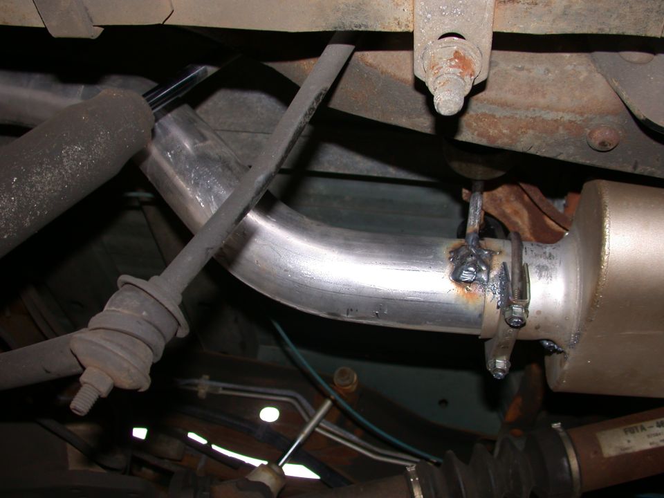 Vehicle underside showing new stainless exhaust pipe clamped to catalytic converter