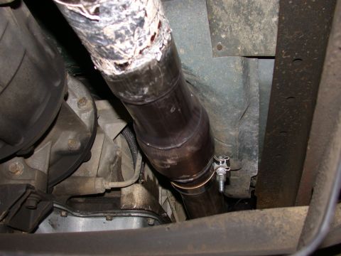1995 Ford Bronco - Underside view of a vehicle's exhaust system and transmission housing.