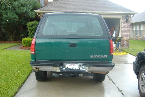 1994 Chevrolet Blazer - Green Chevrolet SUV parked in a driveway, showing its rear end and trailer hitch.