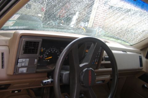 1994 Chevrolet Blazer - The interior of a 1994 Chevrolet Blazer shows a tan dashboard and a black steering wheel with visible gauges.