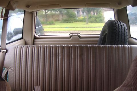 1994 Chevrolet Blazer - View from the back seat shows the ribbed upholstery and a spare tire mounted behind the seat.