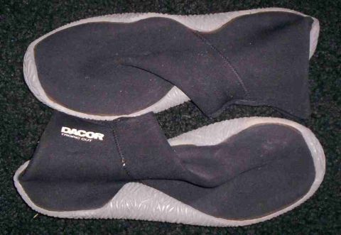 1986 Ford Bronco - A pair of black DACOR TROPIC CUT diving boots with grey soles are shown on a dark carpet.