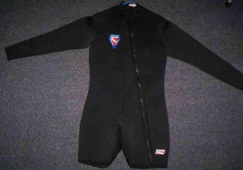 1986 Ford Bronco - A black wetsuit with long sleeves and short legs is laid out flat on a carpeted surface.