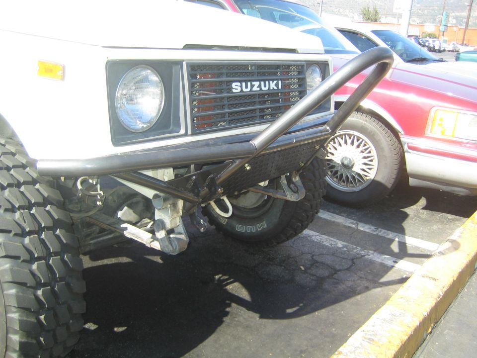 Close-up of Suzuki Samurai front bumper and grille in parking lot