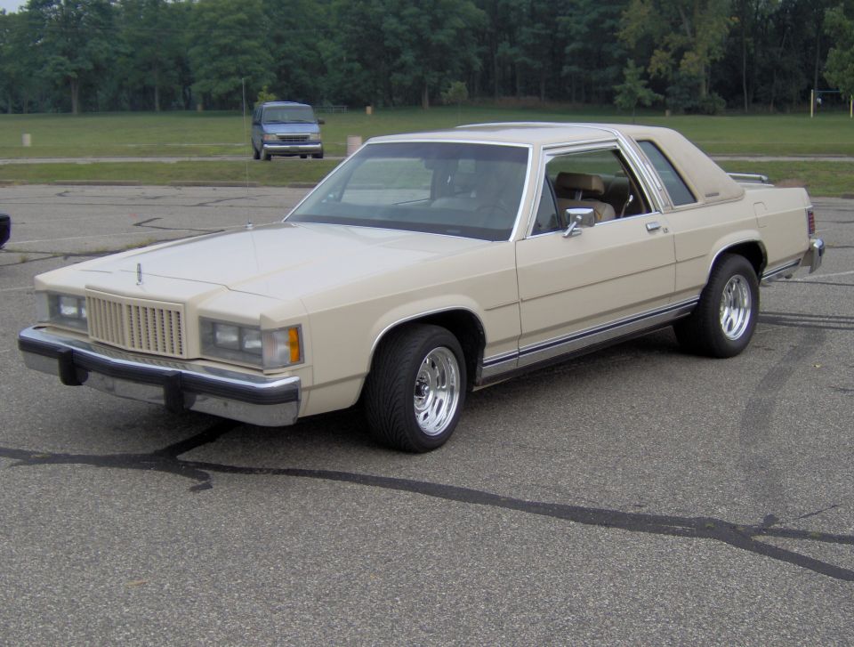 Tan Ford sedan with chrome wheels and vinyl roof