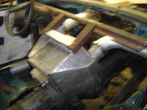 1997 Ford Ranger - The interior of a vehicle shows a custom roll cage and a large metal box installed.