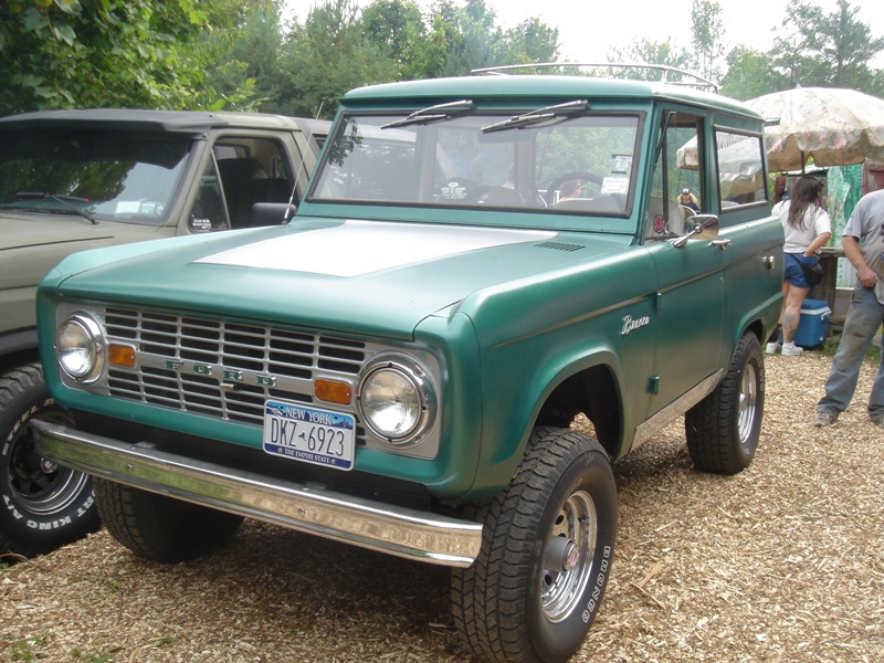 Green Ford Bronco from the front-three-quarter view, showing its grille and New York license plate DKZ-6923