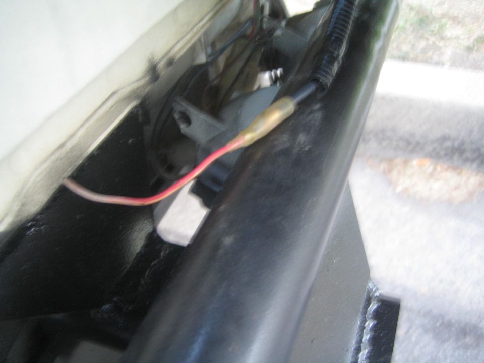 Wiring harness with red wire and yellow connector attached to a black tube
