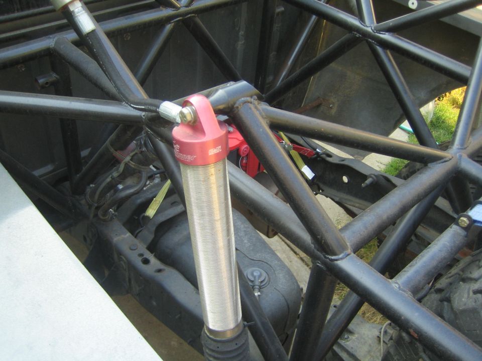 close-up of off-road suspension with red shock absorber and roll cage