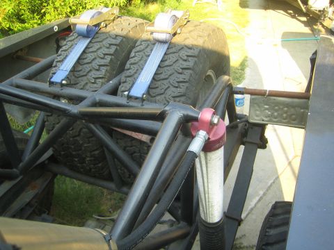 1968 Ford Mustang - Spare tires are strapped down within a custom roll cage, alongside suspension components.