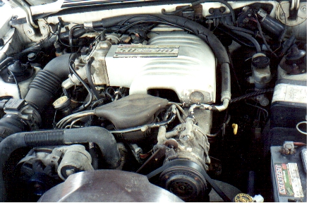 1989 Ford Mustang - Close-up view of a car's engine bay, showing various components and wiring.