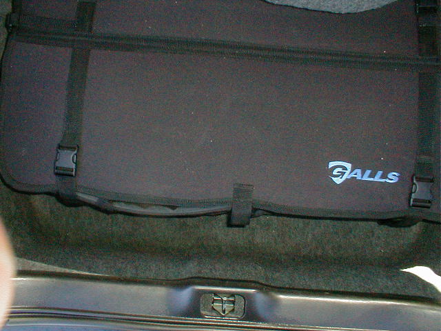 Trunk organizer with Galls logo and straps, sitting in a car trunk