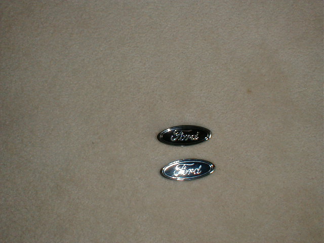 Two Ford oval emblems, one black, one chrome