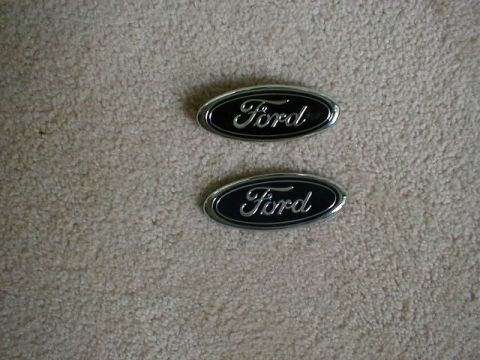 2002 Ford Crown Victoria - Two Ford emblems are shown against a textured background.