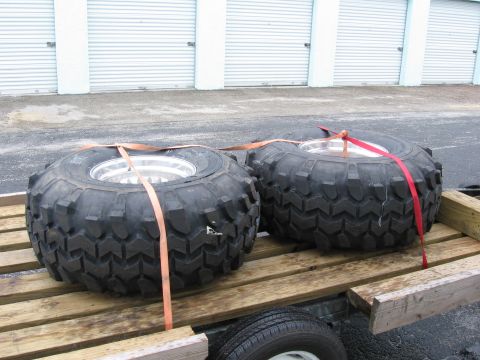 1974 Ford F-100 - Off-road tires are strapped to a trailer, ready for transport.