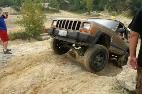 2006 Jeep Liberty - A Jeep Cherokee XJ navigates a challenging off-road course with sandy terrain and inclines.