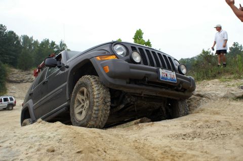 2006 Jeep Liberty - A Jeep Liberty navigates a challenging off-road course with another SUV visible in the background.