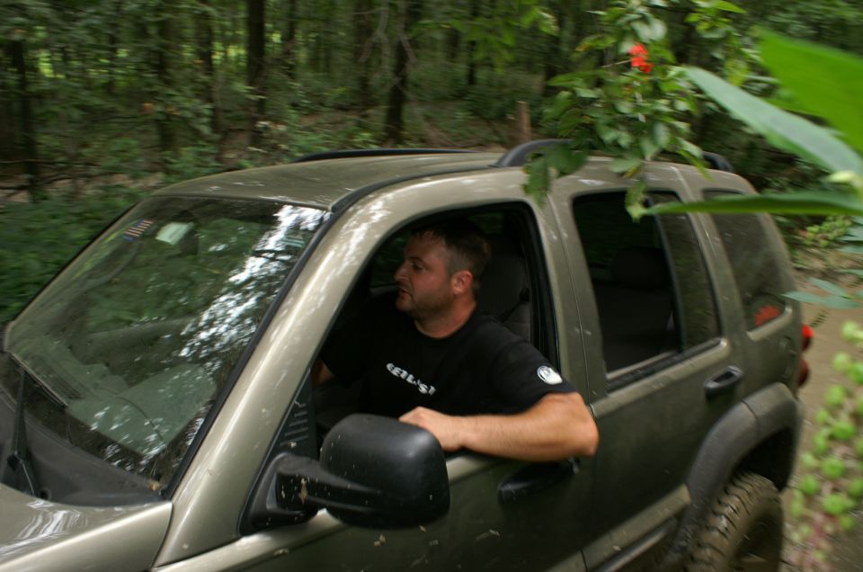 Man driving a 2006 Jeep Liberty through a wooded area
