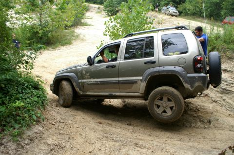 2006 Jeep Liberty - A 2006 Jeep Liberty navigates a challenging off-road course with other vehicles in the background.