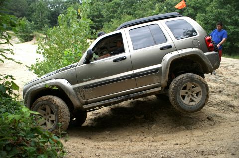 2006 Jeep Liberty - A 2006 Jeep Liberty navigates an off-road trail with a person watching.