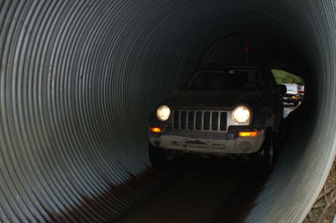 2006 Jeep Liberty - A 2006 Jeep Liberty navigates through a large corrugated metal tunnel, with another vehicle following behind.