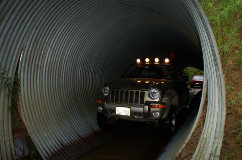 2006 Jeep Liberty - A Jeep Liberty navigates through a corrugated metal tunnel, with another vehicle visible in the distance.