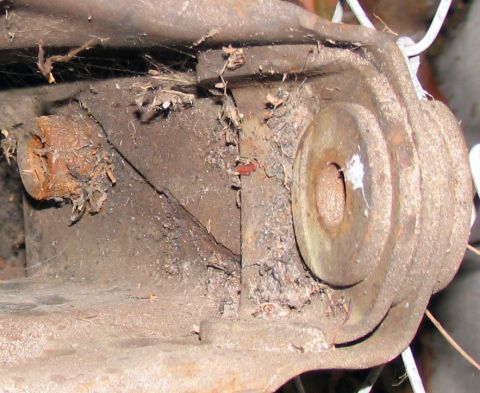 1984 Ford Bronco - Close-up of a heavily corroded metal part, likely from a vehicle's suspension system.