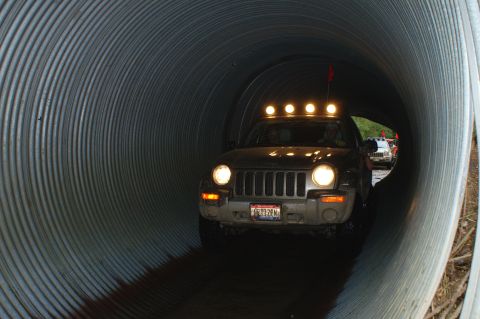 2006 Jeep Liberty - Two Jeep Libertys navigate a large corrugated metal tunnel, one with auxiliary lights on its roof.