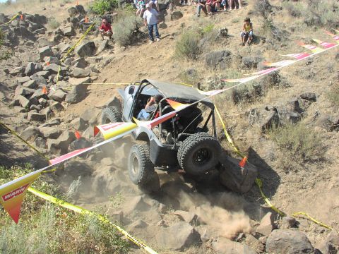 1979 Ford Bronco - A custom off-road vehicle tackles a challenging rock crawling course with spectators observing the action.