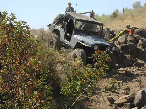 1979 Ford Bronco - Jeep CJ-5 navigates a challenging rocky incline during an off-road event.