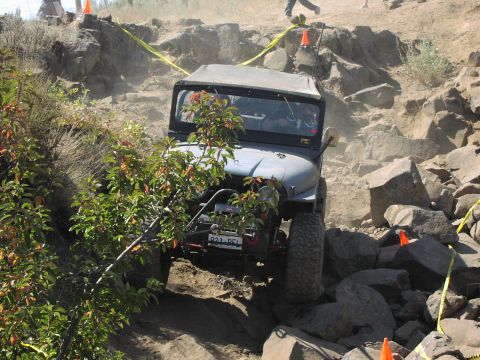 1979 Ford Bronco - A Jeep navigates a challenging rocky terrain during an off-road event.