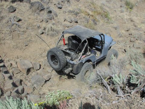 1979 Ford Bronco - An off-road vehicle navigates a challenging, rocky terrain with dust kicking up from its tires.