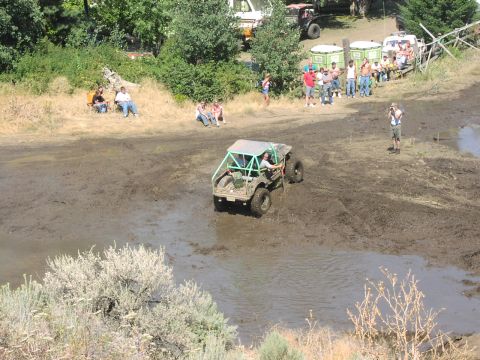 1979 Ford Bronco - A custom off-road buggy tackles a challenging muddy course during an event.