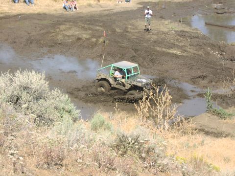 1979 Ford Bronco - Modified off-road vehicle navigates a muddy track during an event.