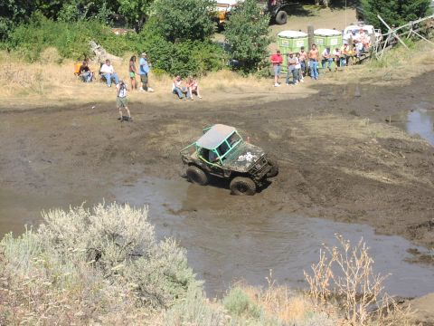 1979 Ford Bronco - A modified off-road vehicle navigates a challenging mud course with onlookers observing the event.