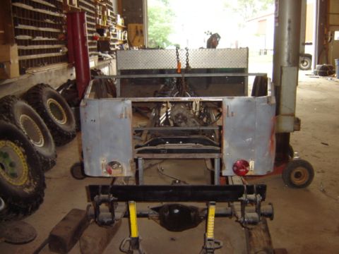 1992 Ford Bronco - This vehicle is in a workshop, undergoing repairs or restoration, with spare tires nearby.