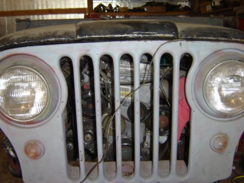 1992 Ford Bronco - Close-up of a Jeep's front end, revealing the engine and radiator behind the vertical grille bars.