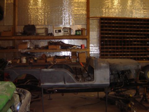 1992 Ford Bronco - Workshop scene with a Jeep CJ-5 body shell undergoing restoration or repair.