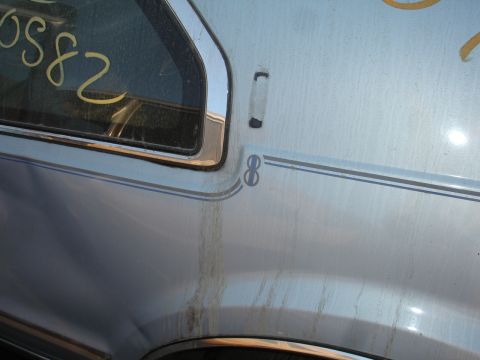 1993 Ford Taurus - A close-up of a light blue car's side shows a stripe with an '8' emblem and yellow writing on the window.