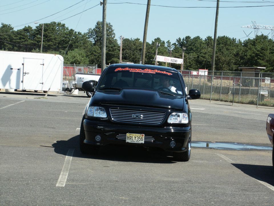 Black Ford F-150 SVT Lightning with aftermarket hood and grille