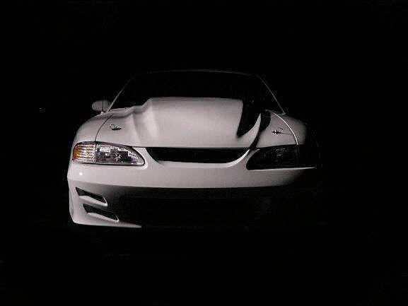 White Ford Mustang with cowl hood scoop, front view on black background