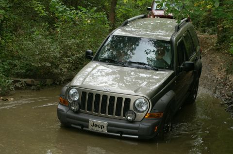 2006 Jeep Liberty - A Jeep Liberty navigates a water crossing on a wooded trail, with another vehicle following behind.