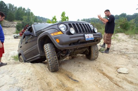 2006 Jeep Liberty - A 2006 Jeep Liberty is stuck in the dirt while two men observe the situation.